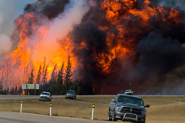Flames tower above the treeline next to Highway 63 south of Fort McMurray, Alberta, Canada, on May 7, 2016.